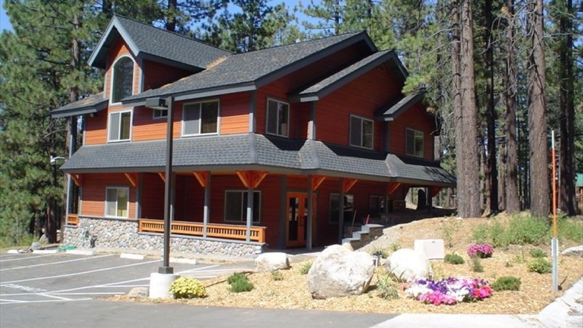 a house that has a sign on the side of a road